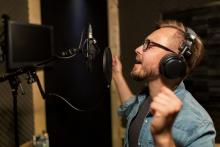Voice Actor In Studio Voice Actor speaking into studio mic