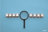 A magnifying glass in the middle of a line of profiles